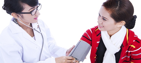 Doctor checking blood pressure of patient isolated in white